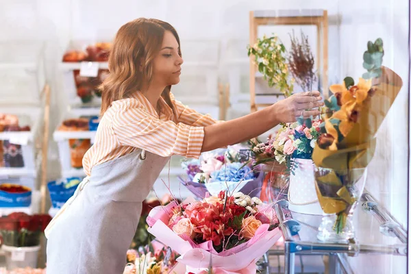 Serieuze hardwerkende bloemist geconcentreerd op werken — Stockfoto