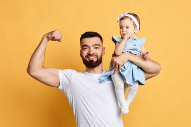 yakışıklı pozitif baba onun sevimli küçük kızı tutarken pazı gösteren