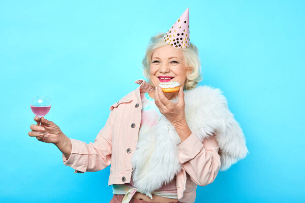 старшая очаровательная женщина веселится на свой день рождения
