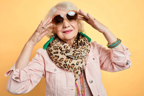 Гламурная женщина в стильных солнцезащитных очках позирует перед камерой — стоковое фото