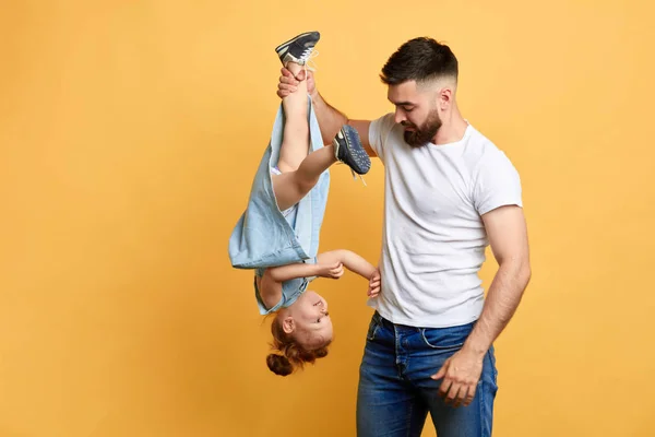 angry frustrated guy holding his naughty sisters leg and scolding her