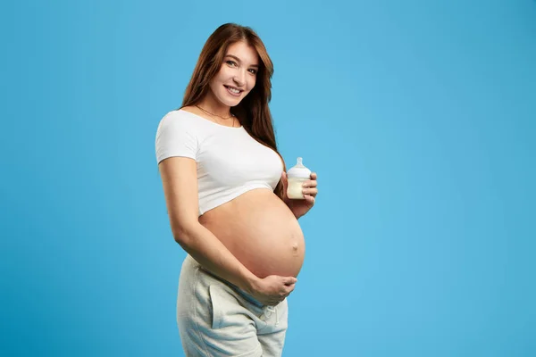 Positive charmante Mädchen mit Milchflasche und Blick in die Kamera — Stockfoto