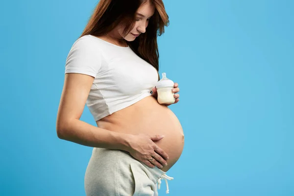 Mulher segurando um nad biottle falando com seu bebê — Fotografia de Stock