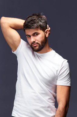 Beyaz şık t-shirt saç dokunmadan giyen yakışıklı sakallı adam