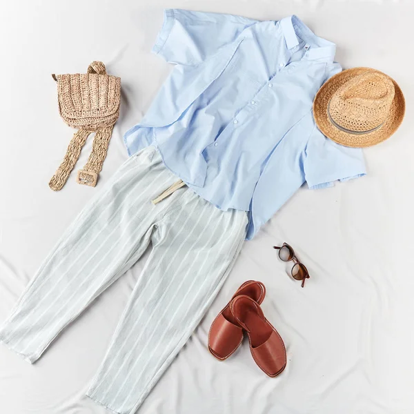 Camisa azul claro, pantalones a rayas, sandalias, bolso de punto, sombrero de paja — Foto de Stock