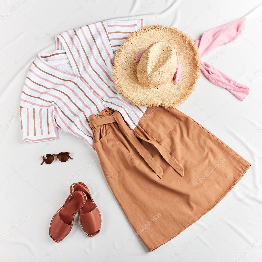 skirt, shirt, straw boater hat, leather brown sandals on white background.