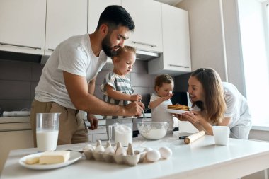krep ile bir tabak tutan çekici gülümseyen kadın, küçük kızı onları veren