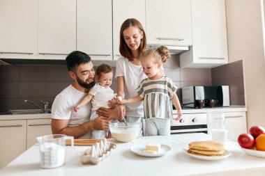 neşeli gülümseyen çift ve çocukları lezzetli pasta koklama