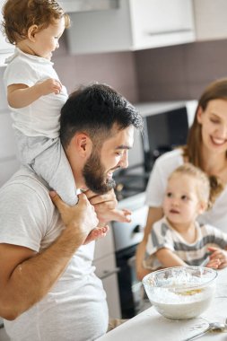 annelerini kontrol eden omzunda oturan baba ve bebek