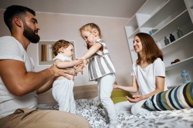 müthiş genç ebeveynler ve çocukları yatakta dans