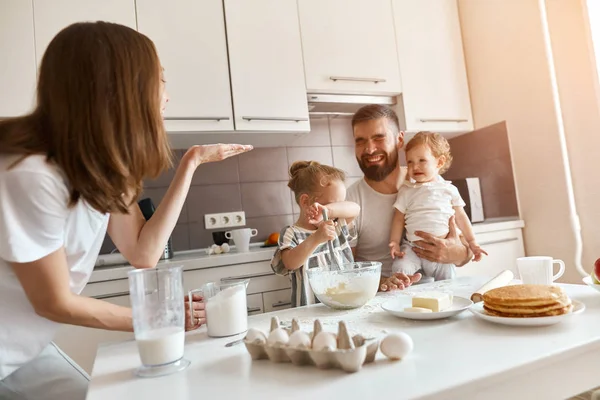 Funny crazy brown-haired mommy blowing flour to his husband and kids — Stock Photo, Image
