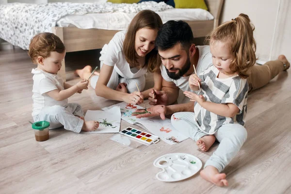 Yaratıcı çift ve çocukları dedesi için bir hediye hazırlanıyor — Stok fotoğraf