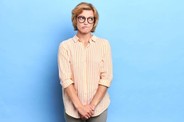 Güzel emin olmayan utangaç timmid genç sarışın öğrenci gözlük dudaklarını ısırma