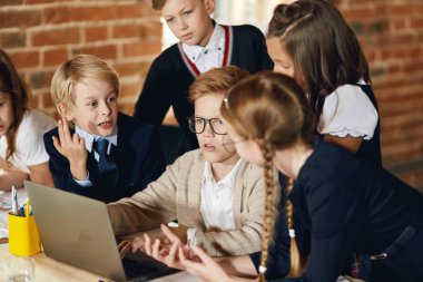 zeki zencefil çocuk dizüstü bilgisayarda bir şey yazarak arkadaşları onu helaping ise
