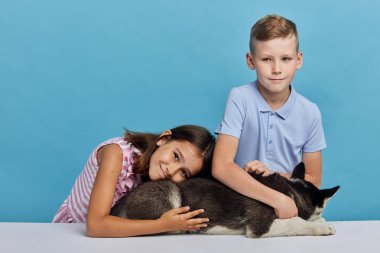 onların sevimli evcil hayvan ile iki çocuk, kameraya bakarak sarılma