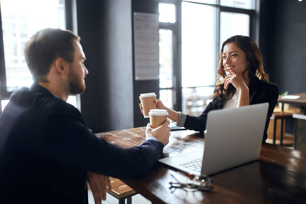 Cheerful office workers holding cups of tea