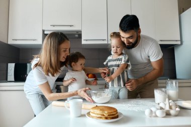 Ablası ve ailesi ona yardım ederken çırpıcı macunu tutan kız.