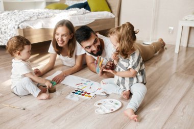 gülümseyen aile renklerle el izi yapıyor