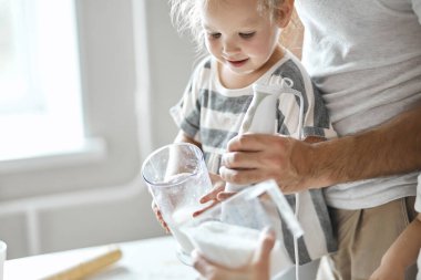 Gülümseyen küçük kız ailesine yardım ediyor.