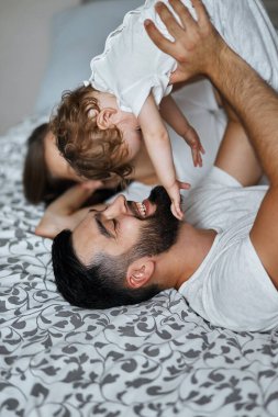 Mutlu genç aile bebekleriyle oynuyor.