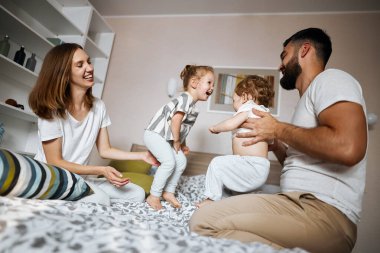 Neşeli, harika, genç ebeveynler çocuklarla vakit geçiriyor.