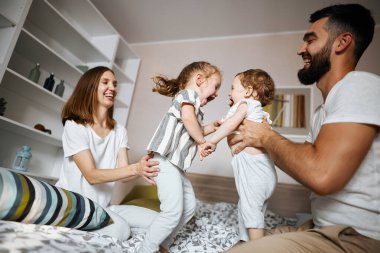 Neşeli, çekici ebeveynler çocuklarını eğlendiriyorlar.