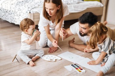 Küçük bebek elinde suyla bir bardak tutuyor