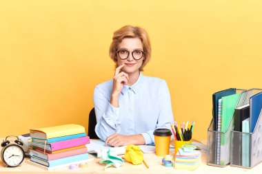 Çekici, gülümseyen genç bir kadın çenesine parmağıyla dokunuyor