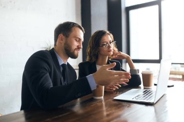 Aktif hırslı bir adam başarılı projesini bir meslektaşına sunuyor.