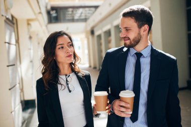 Genç mimarlar cadde boyunca yeniden birleştirilmiş binalarla yürüyorlar