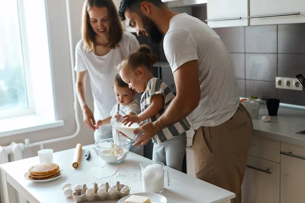 Little girl helping her father and mother with cooking — Stock Photo, Image
