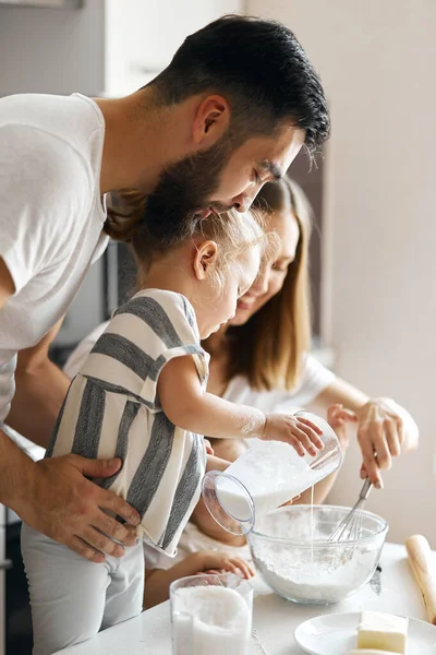 Little girl pouring milk to pastry — Stock Photo, Image