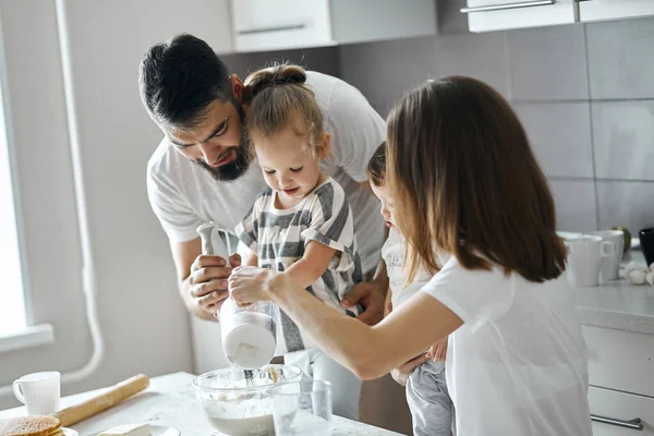Fiatal pár és gyermekük időtöltés a konyhában — Stock Fotó