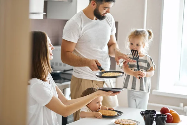 Talented husband treting his family with yummy pancakes in the morning — Stock Photo, Image