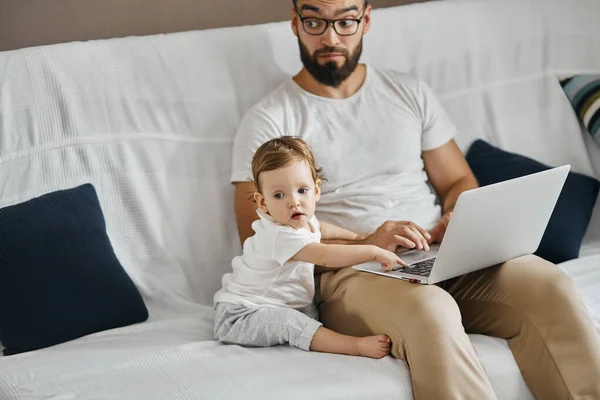 Fiatal apa és a baba szörfözik a neten, böngészi a neten — Stock Fotó
