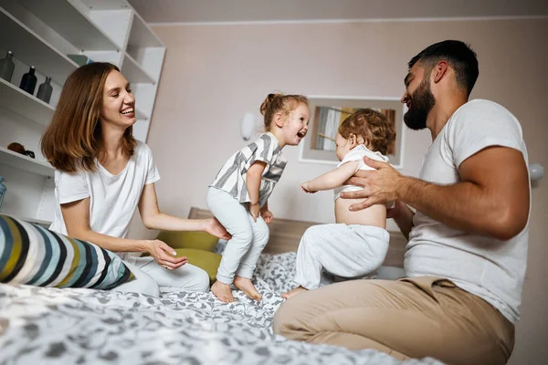 Cheerful awesome young parents spending time with kids — Stock Photo, Image