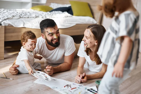 Padres jóvenes agradables riendo, disfrutando del tiempo con los niños —  Fotos de Stock