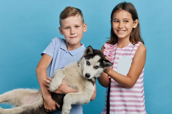 Bambini felici sono stati dati un animale domestico dai loro genitori il giorno del compleanno — Foto Stock