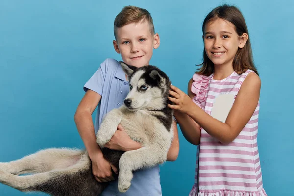 Bambini felici sorridenti hanno un nuovo animale domestico, gioendo di avere un nuovo amico — Foto Stock