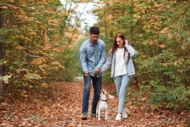 İki evcil hayvan sever dışarıda köpekle eğleniyor.