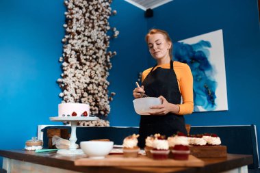 Çalışkan ev hanımı aile için tatlı hazırlıyor.