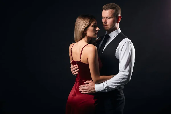 Красива пара в елегантному одязі обіймається, стоячи обличчям до обличчя — стокове фото