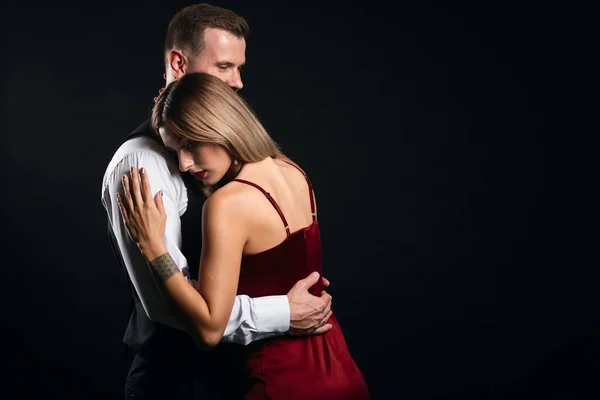 Joven elegante hombre apoya a su mujer, abrazándola — Foto de Stock