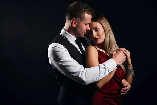 Tişörtlü hoş bir adam kadın elbisesini çıkarıyor.