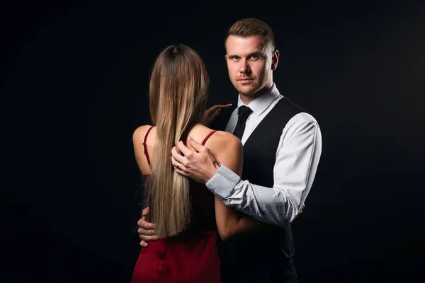 Junger starker Mann im Modeanzug umarmt seinen Mann und schaut in die Kamera — Stockfoto