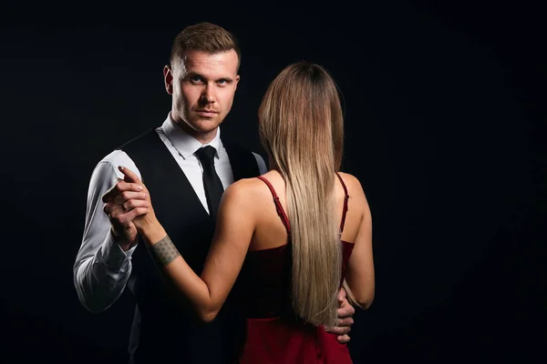 Elegante hombre de la moda sosteniendo su mano ladys mirando a la cámara —  Fotos de Stock