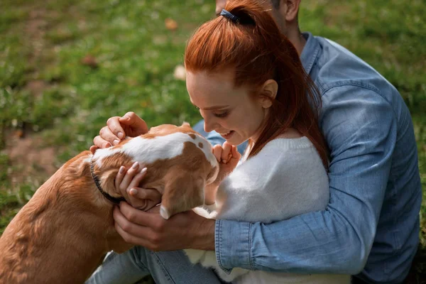 Ingwer glückliches Mädchen und schöner Mann umarmt ihr Haustier — Stockfoto