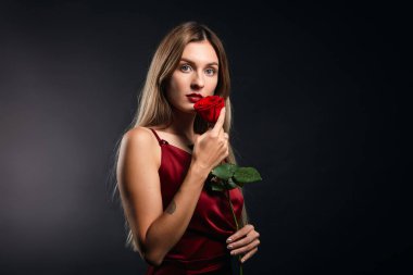 Kırmızı elbiseli romantik, çekici bir kadın randevu sırasında çiçek aldı.
