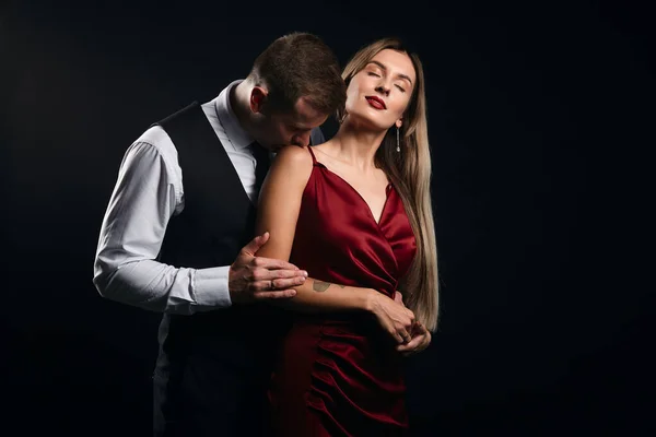 Tişörtlü hoş bir adam kadın elbisesini çıkarıyor.