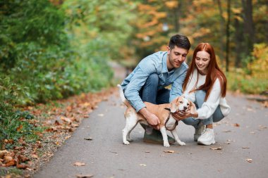 Genç adam ve kadın köpeklerini evcilleştiriyorlar.